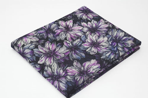 Folded fabric with purple floral pattern on a white background