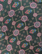 Patterned fabric with floral designs on a dark green background