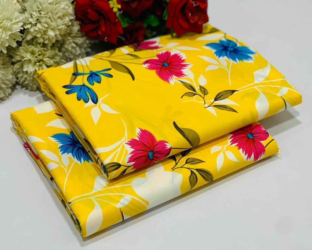 Two yellow fabric sheets with floral patterns on a white background