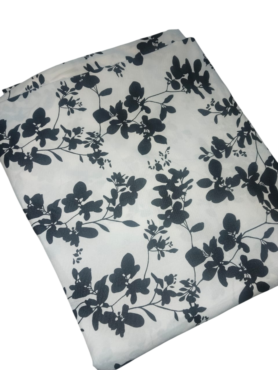 Folded fabric with black floral pattern on a white background