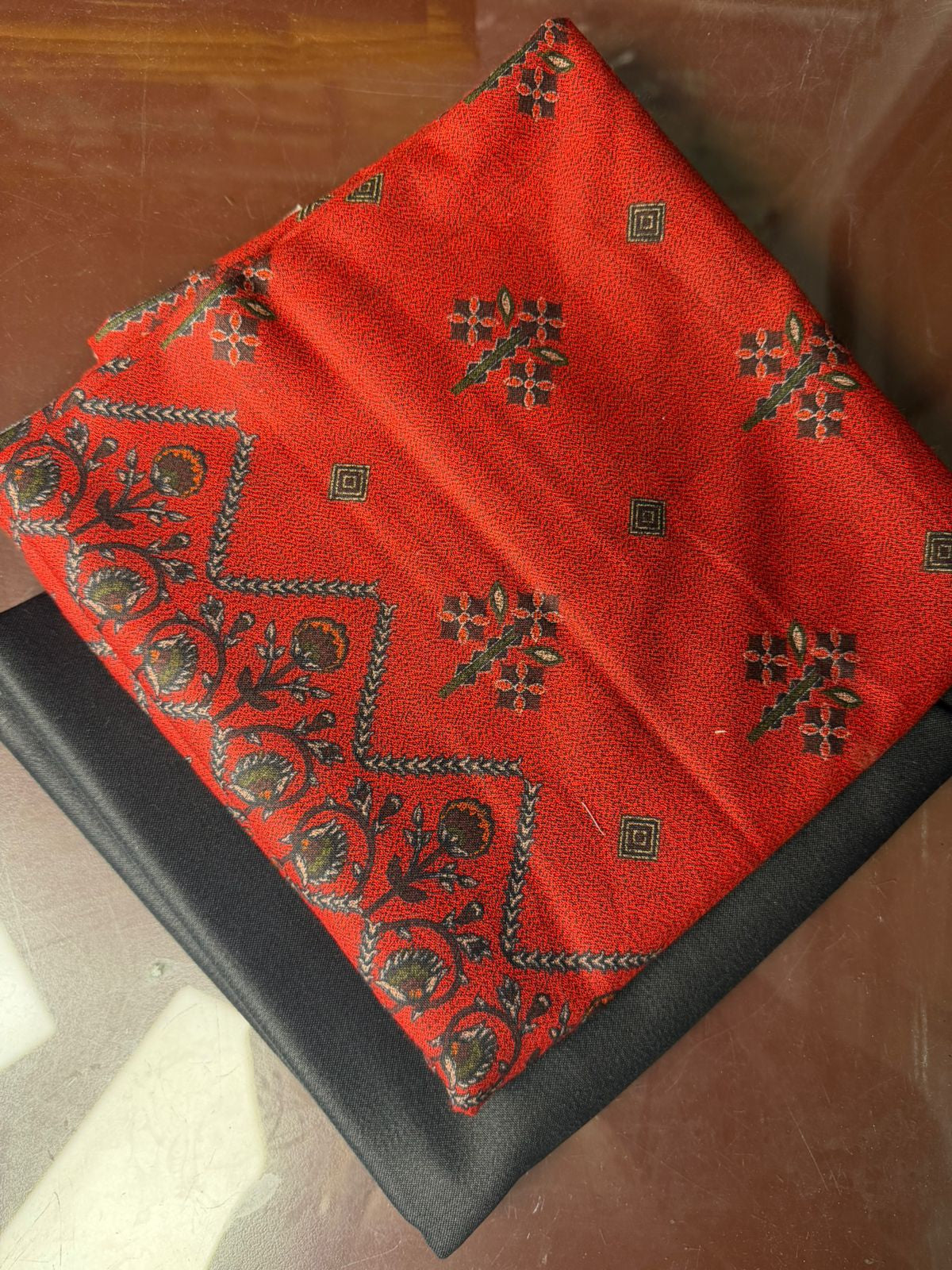 Red embroidered fabric on a black surface