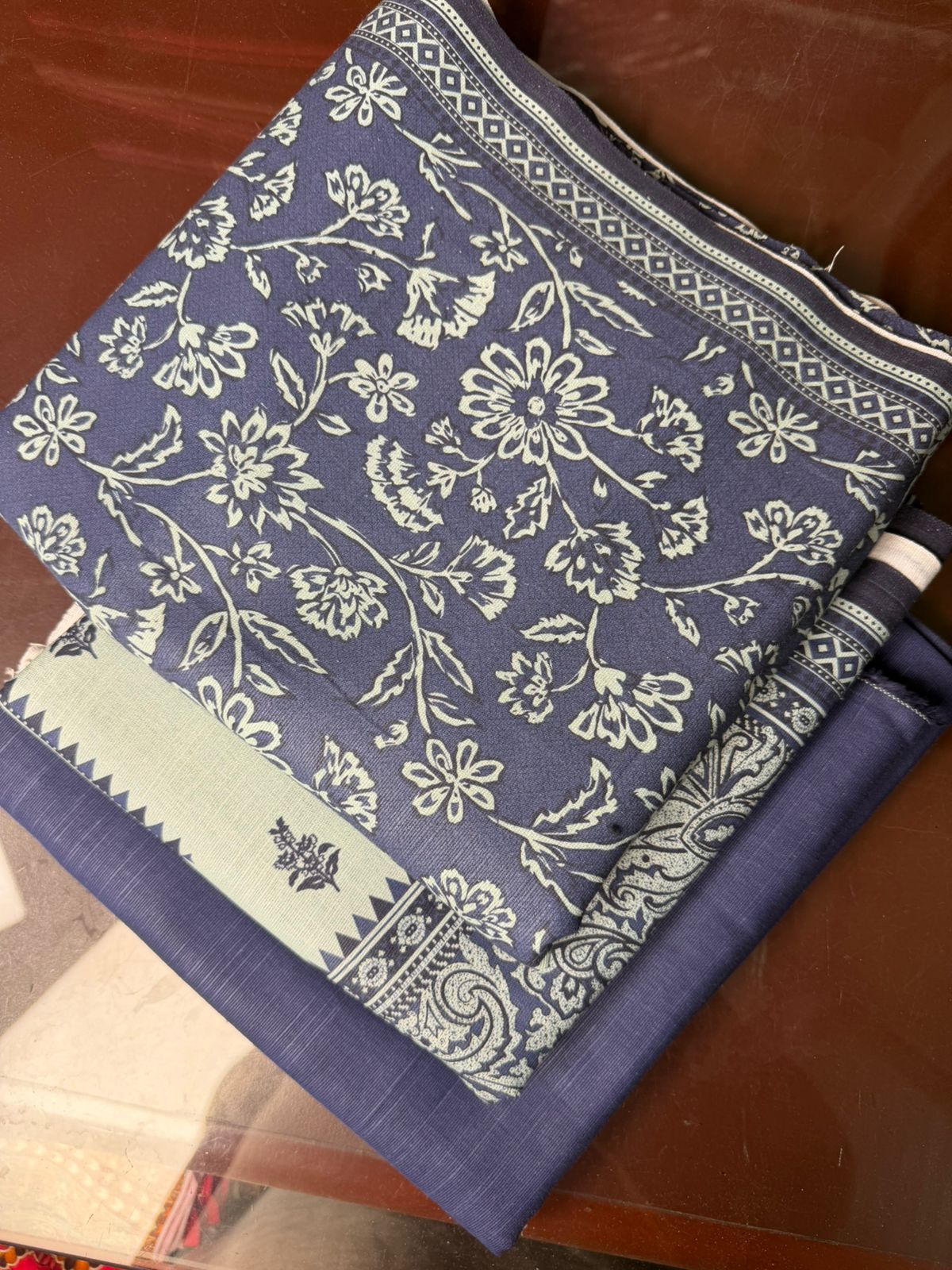 Blue fabric with white floral pattern on a wooden surface