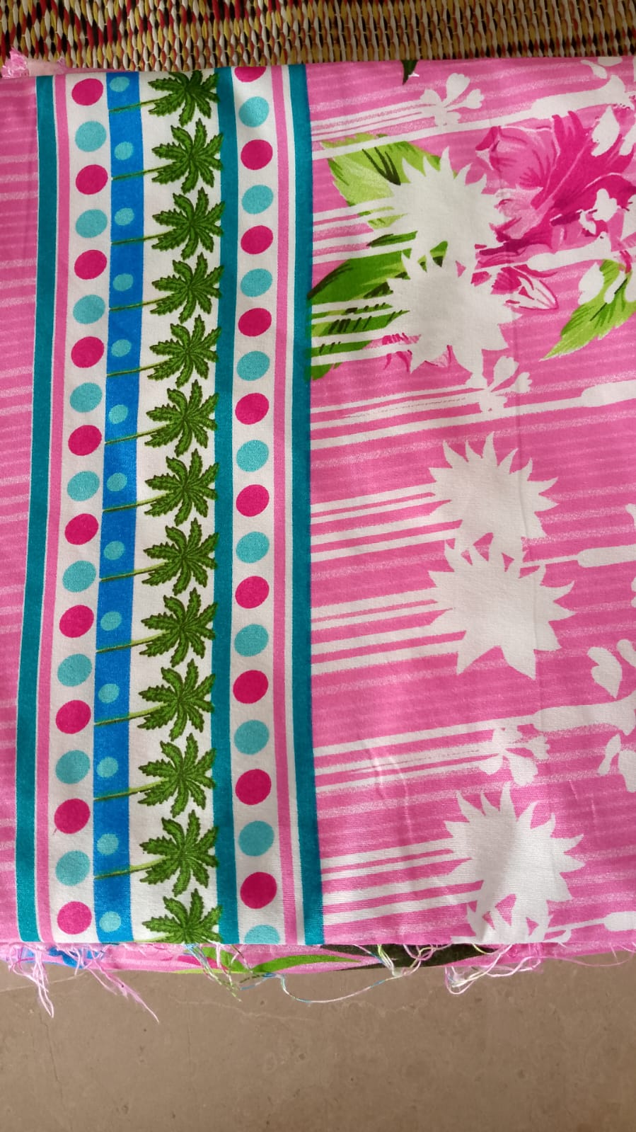 Fabric with pink floral pattern and green leaf design on a striped background