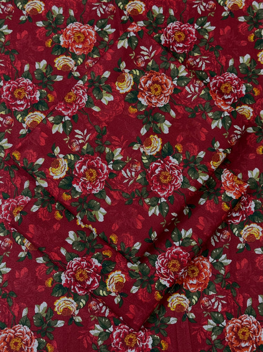 Red fabric with a floral pattern featuring pink and yellow flowers.