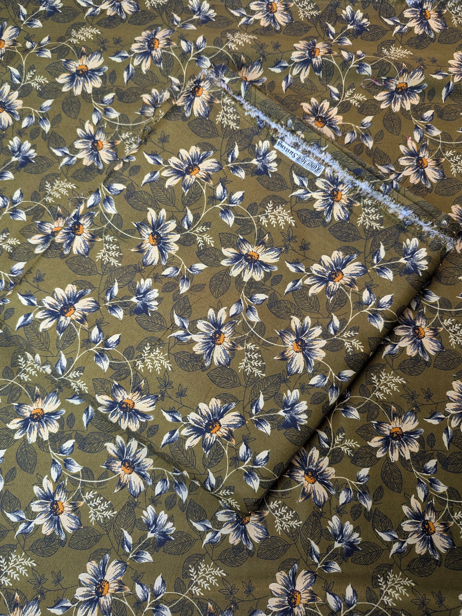 Floral patterned fabric with blue flowers on a green background