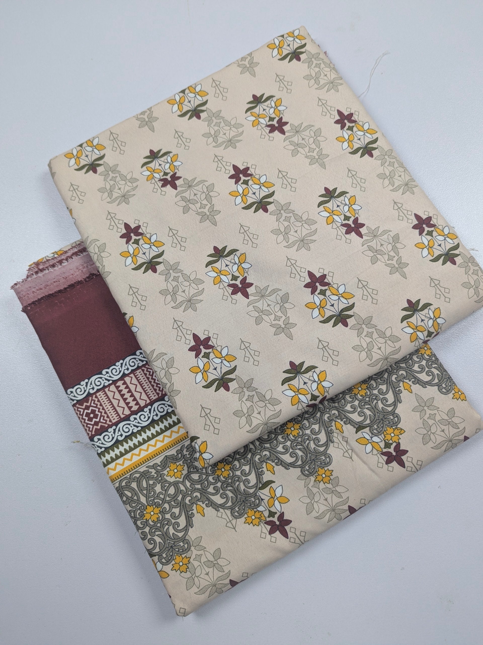 Two fabric swatches with floral and geometric patterns on a white background