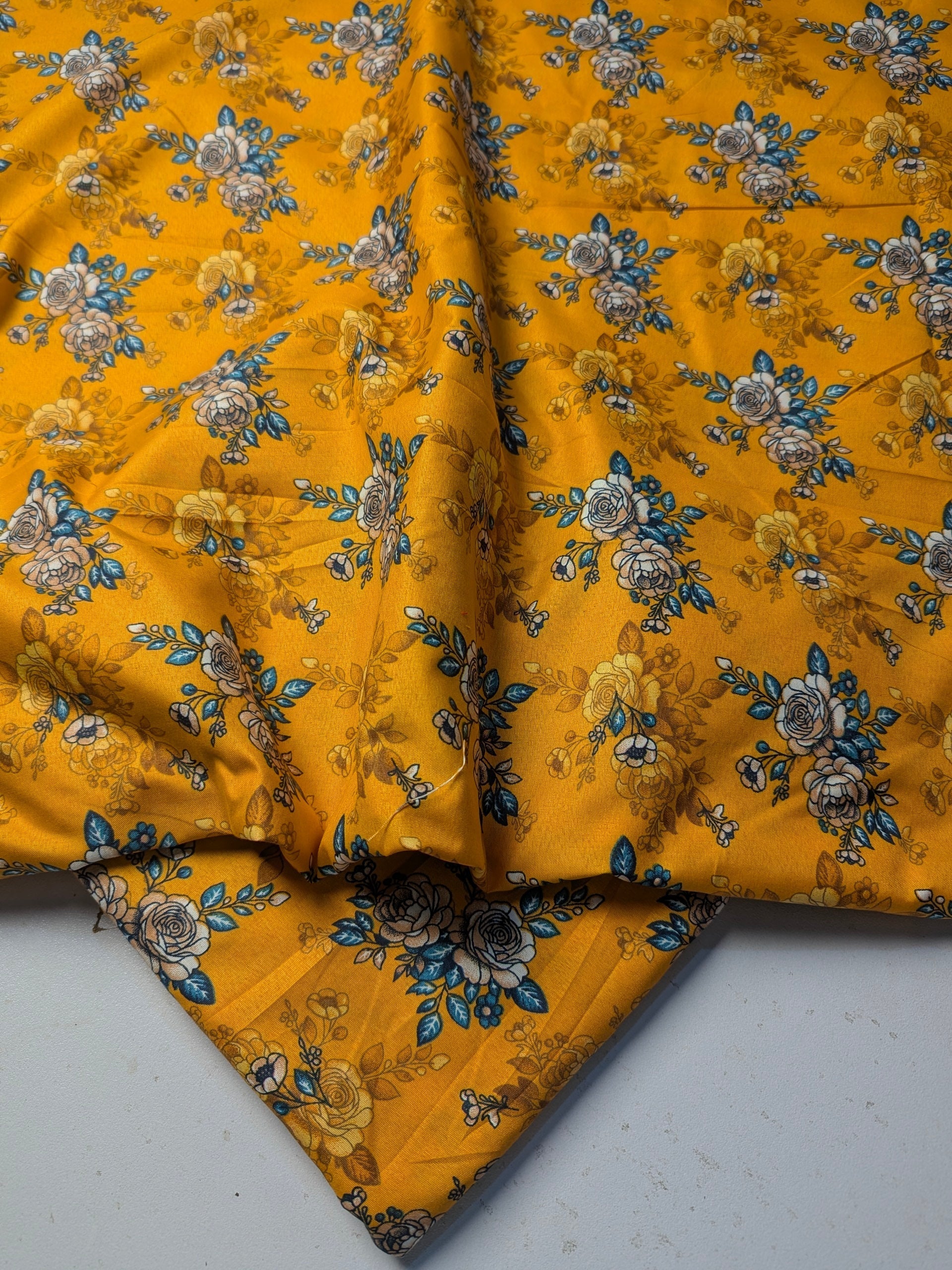 Yellow fabric with floral pattern on a gray surface