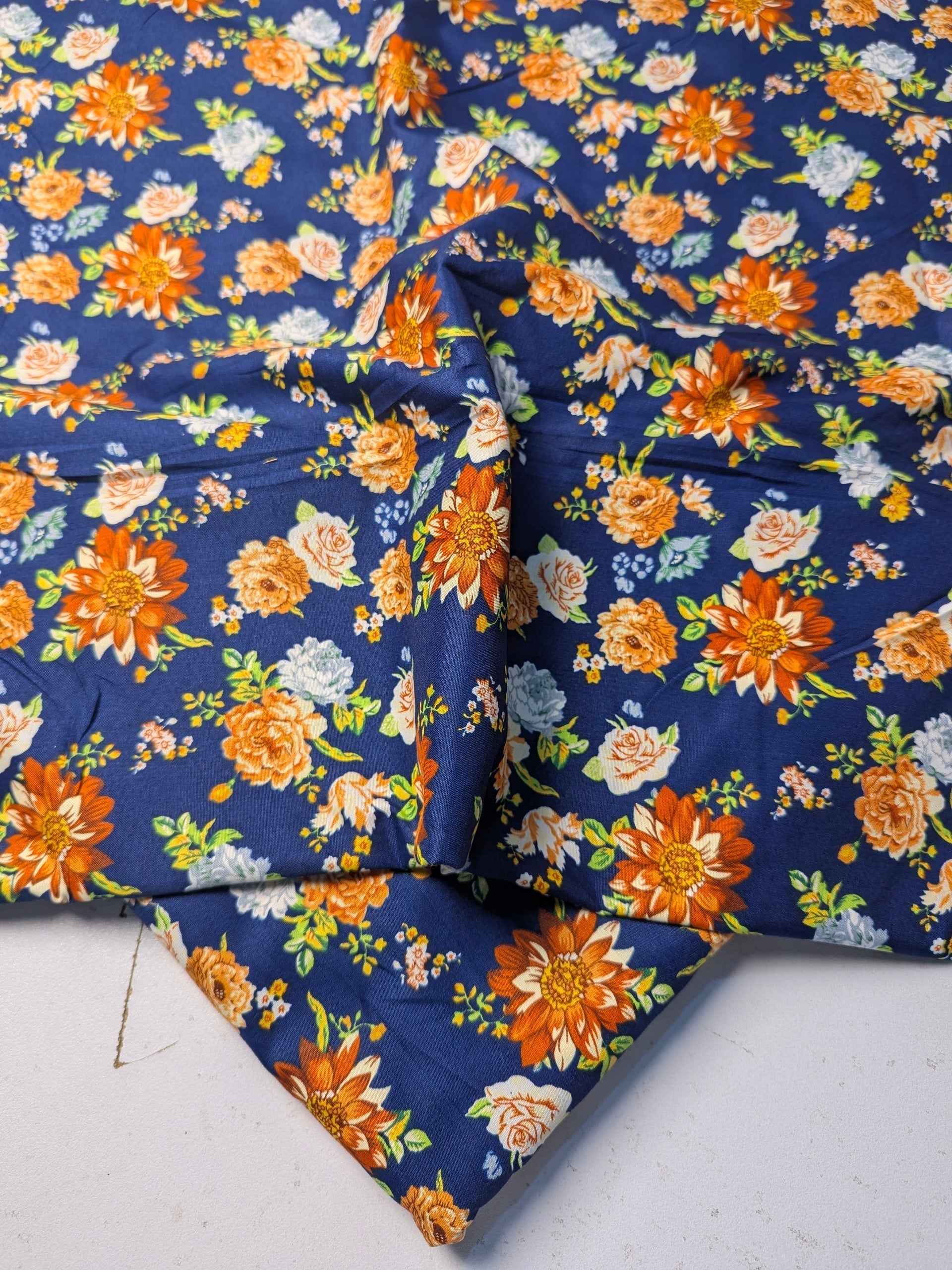 Floral fabric with orange and blue pattern on a white background