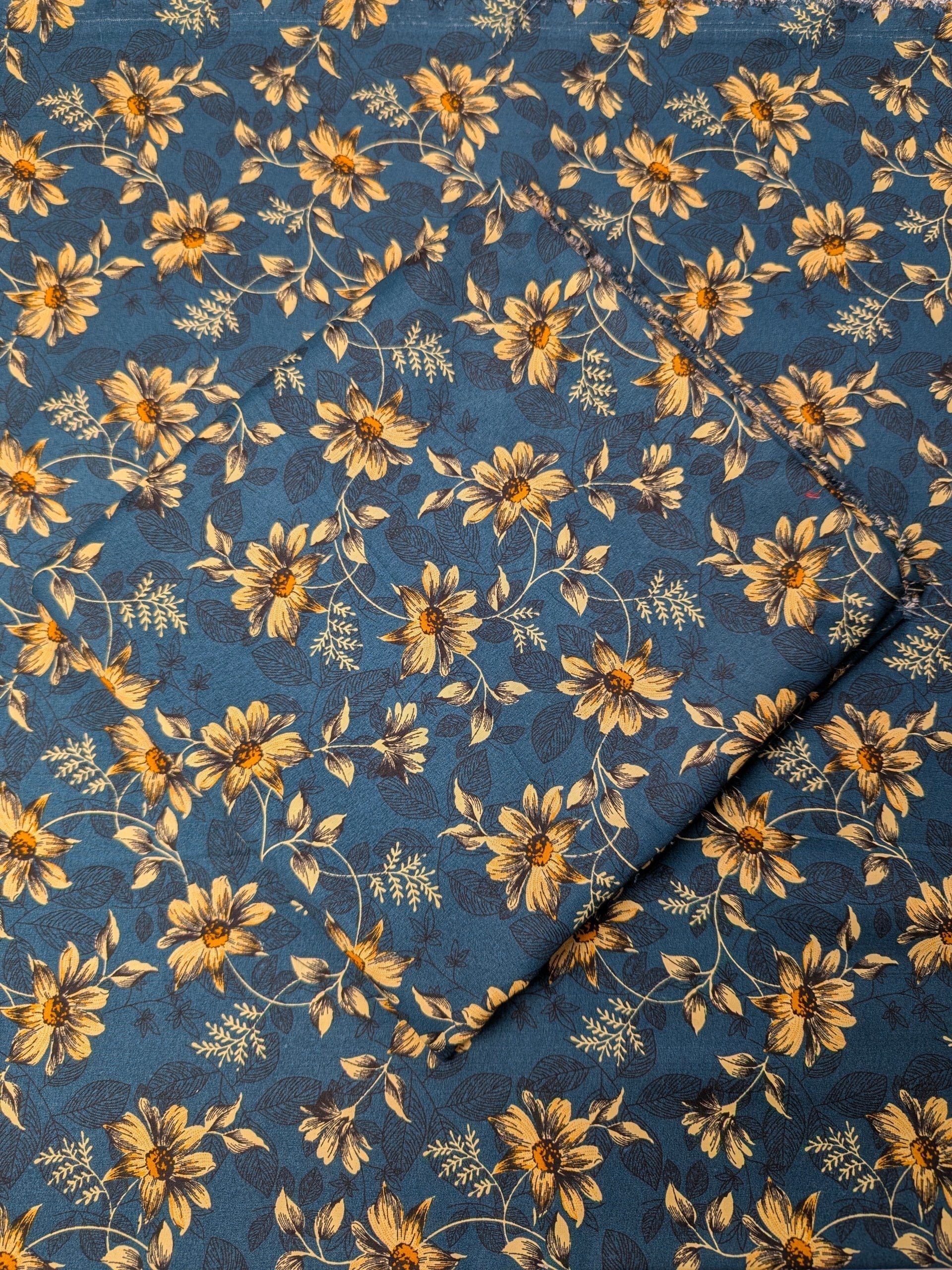Floral patterned fabric with yellow flowers on a blue background